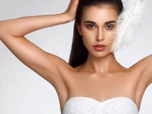 woman holding her arms up and showing clean underarms woman holding her arms up and showing clean underarms